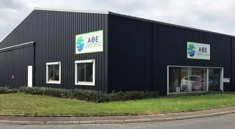 Scène industrielle intérieure montrant un système de chauffage avec chaudière blanche équipée de vannes dorées, manomètres et régulateurs