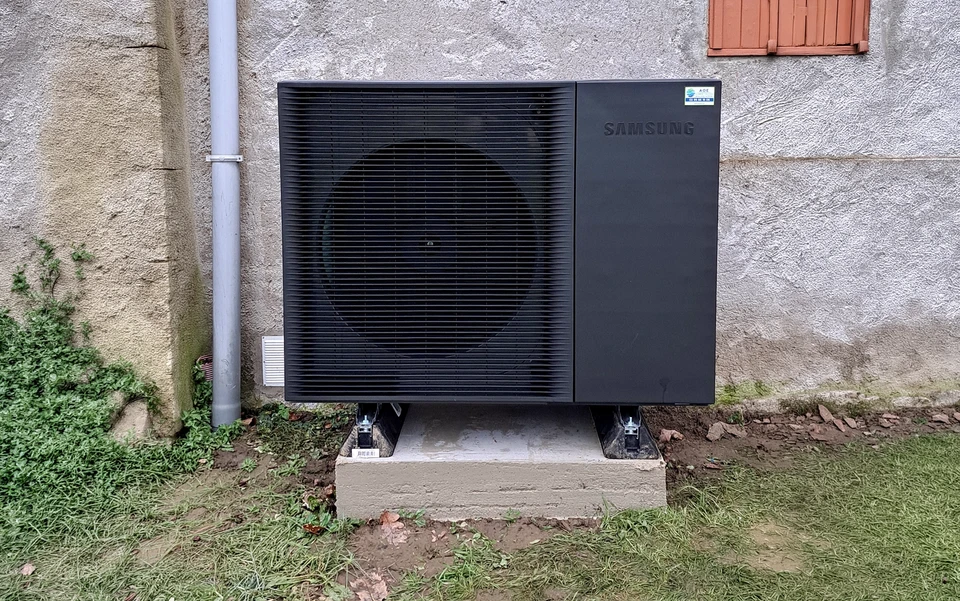 Une pompe à chaleur à air moderne installée dans la chaudière de la maison, des tuyaux en plastique visible et des valves